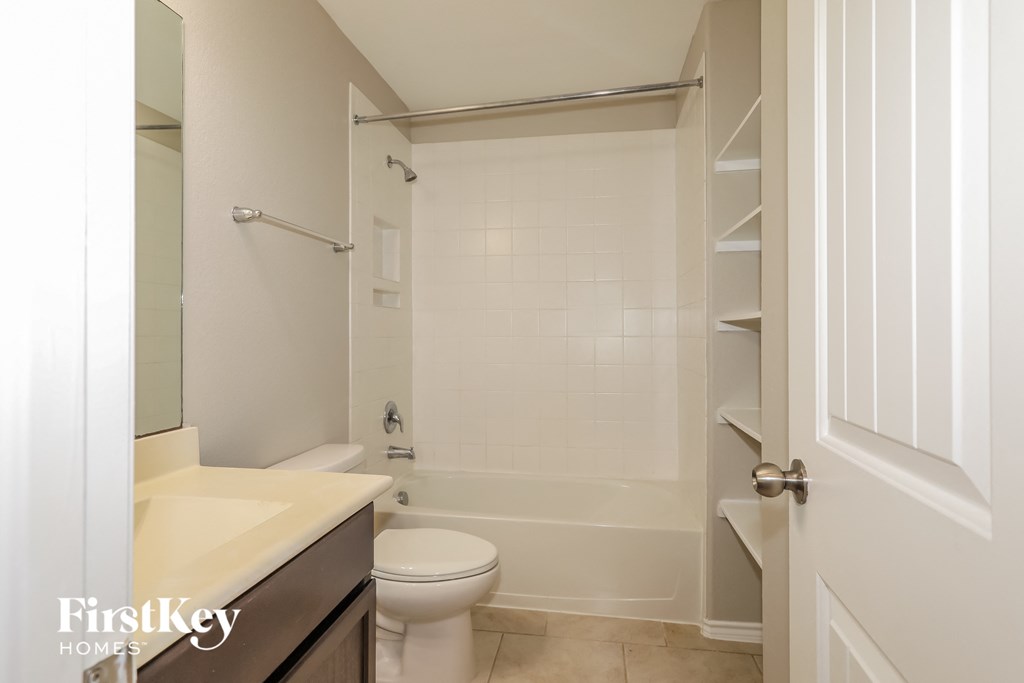 a bathroom with a toilet and a tub and a sink
