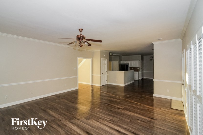 a living room with wood floors and a ceiling fan