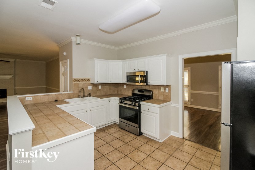 a kitchen with white cabinets and a stove and a refrigerator