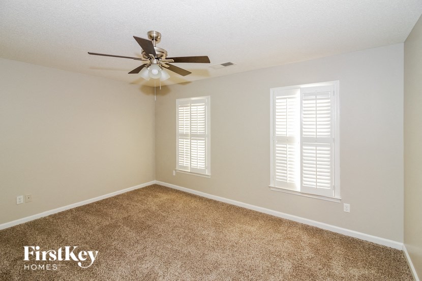 a bedroom with carpet and a ceiling fan