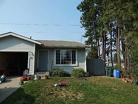 a blue house with a yard and a garage