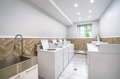 A modern bathroom with a stainless steel sink and white cabinets.