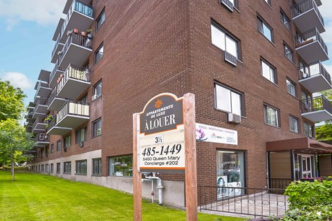 Apartment building with a sign that says "ALOUISER" in front of it.