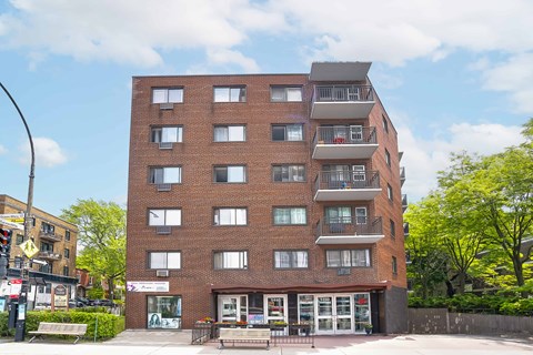 A red brick building with a balcony on the top floor.
