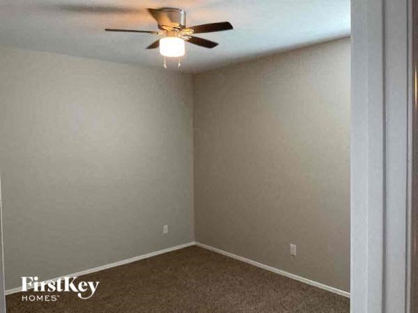 an empty room with a ceiling fan and a light