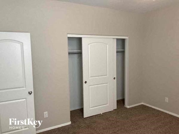 an empty bedroom with two doors and a closet