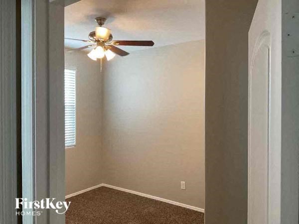 an empty room with a ceiling fan and a window