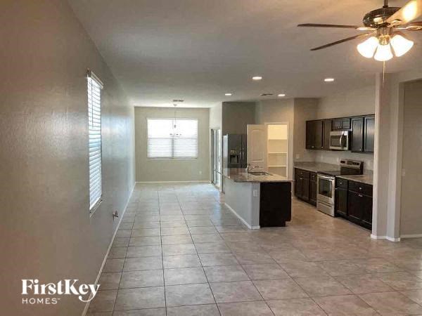 a large empty kitchen with a ceiling fan