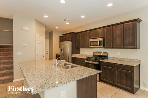 A kitchen with brown cabinets and a granite countertop.