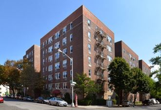 a tall brick apartment building with a fire escape
