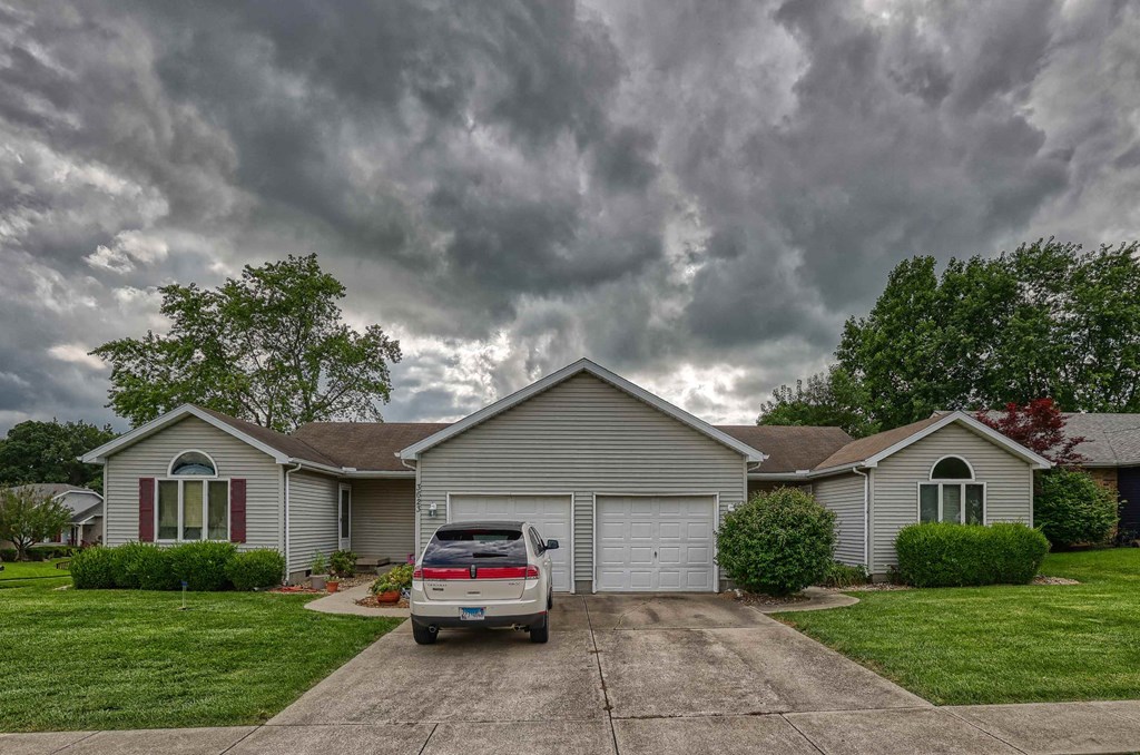 A house with a car parked in front of it.