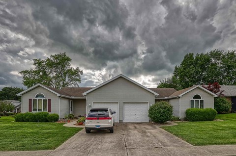 A house with a car parked in front of it.