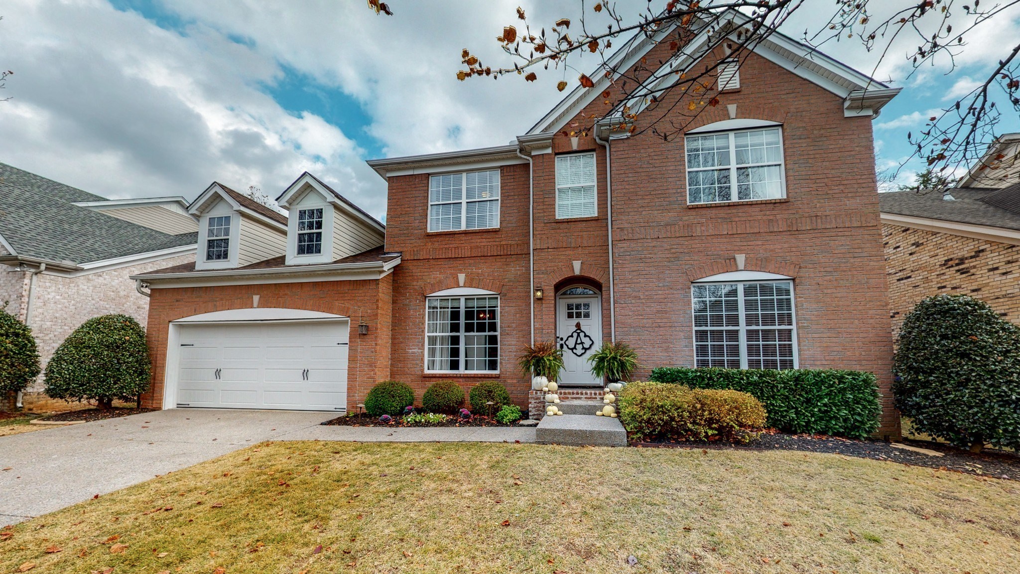 a brick house with a white garage door and a lawn