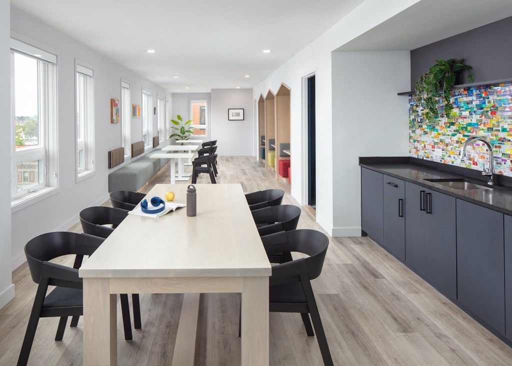 A modern dining room with a long table and chairs.