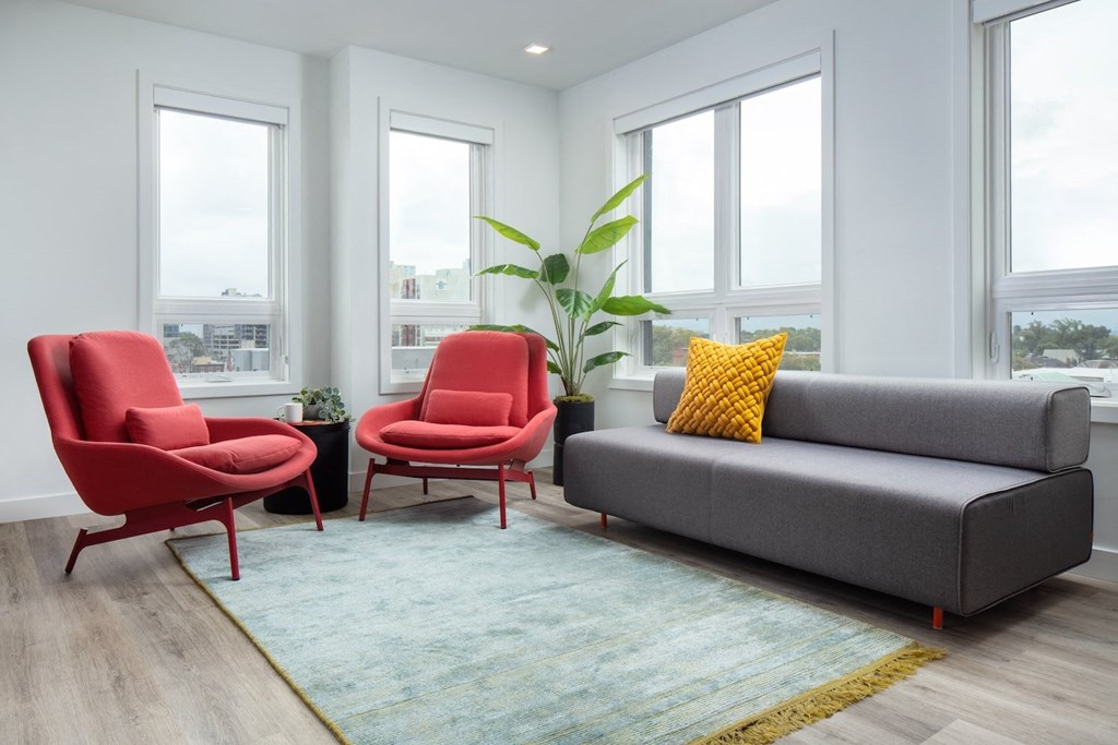 a living room with a couch and chairs and a rug