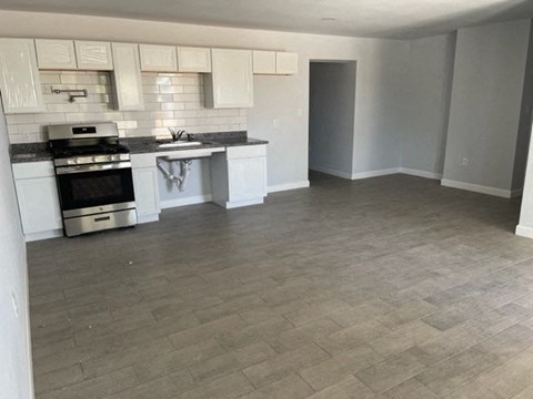 an empty kitchen with a stove and a sink