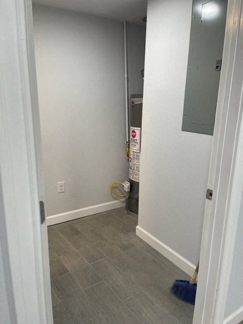 a hallway with a door open and a broom on the floor