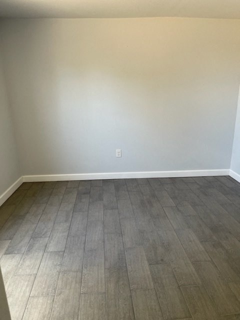 a empty room with wooden floors and white walls