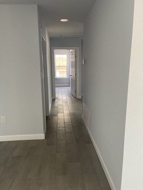 a hallway with a wood floor and a window