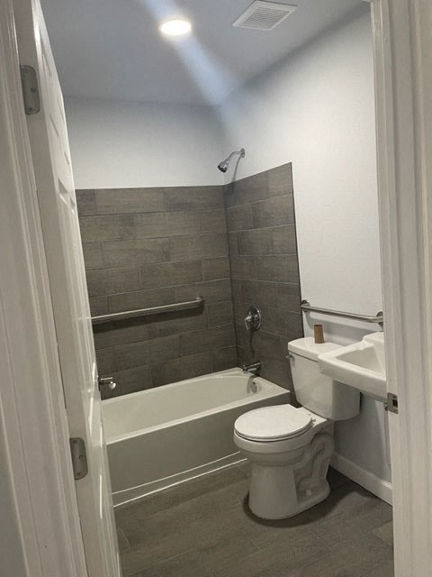 a bathroom with a toilet and a tub and a sink