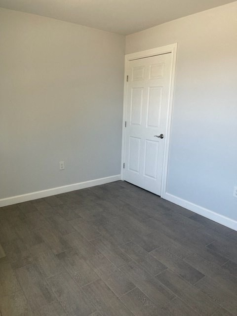 a room with a white door and wood flooring