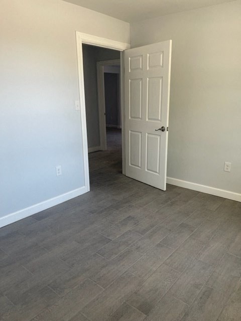 an empty room with a white door and a hallway