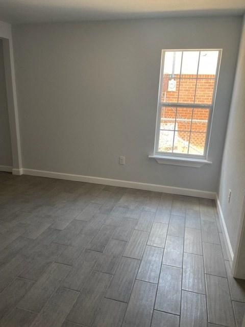 a empty room with a window and wooden floors