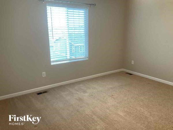 an empty room with a window and a carpet
