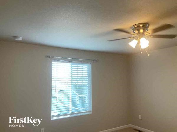 a bedroom with a ceiling fan and a window