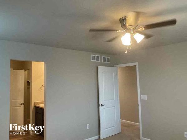 a bedroom with a ceiling fan and a door