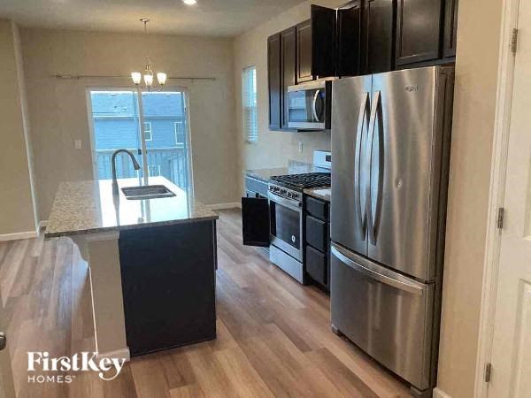 a kitchen with stainless steel appliances and wooden floors