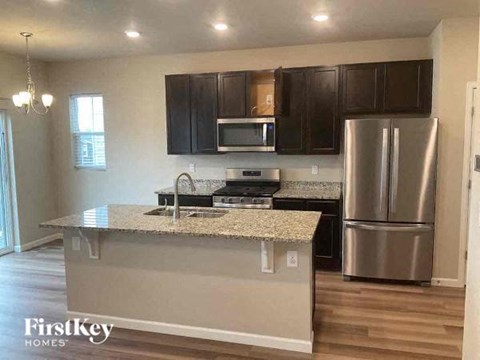 a kitchen with a counter top and a stainless steel refrigerator