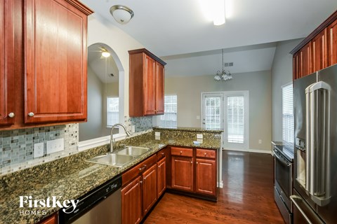A kitchen with wooden cabinets and granite countertops.