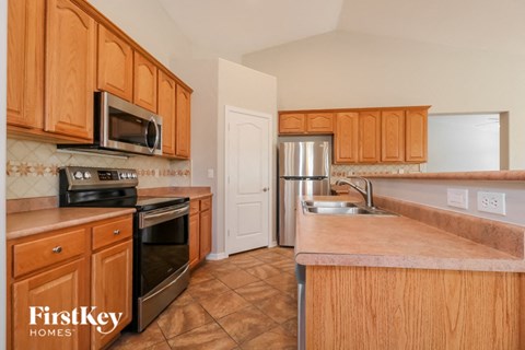 A kitchen with wooden cabinets and a tiled backsplash.