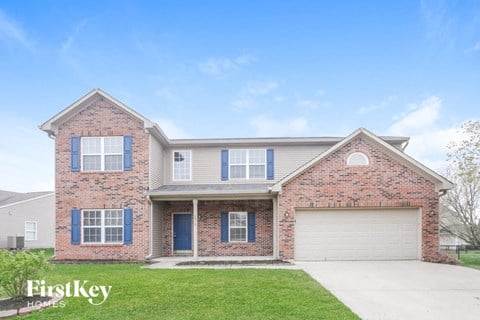 A brick house with a garage door and a blue door.