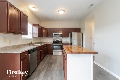 A kitchen with brown cabinets and a wooden island.