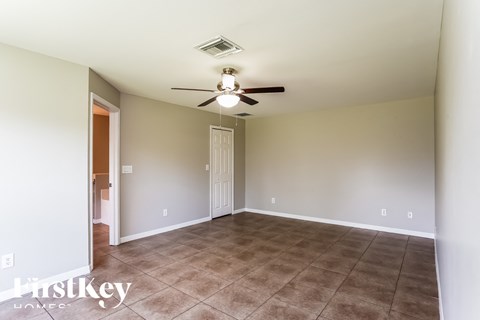 a living room with a ceiling fan and a tiled floor