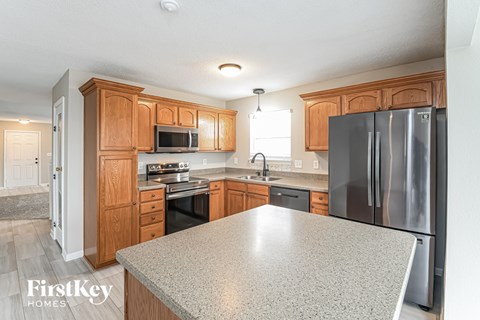 a kitchen with granite countertops and wooden cabinets and stainless steel appliances