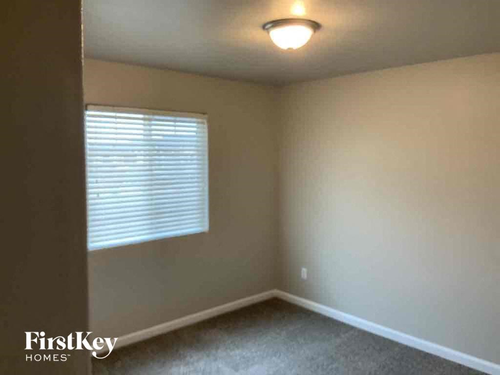 an empty room with a window and a light on the ceiling