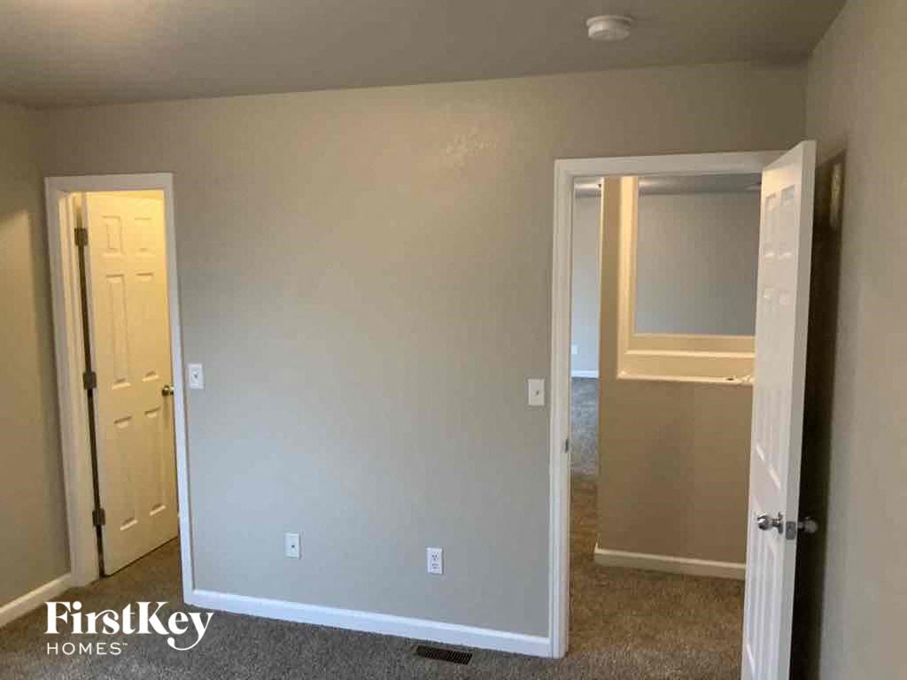 an empty room with a hallway and a door to a closet