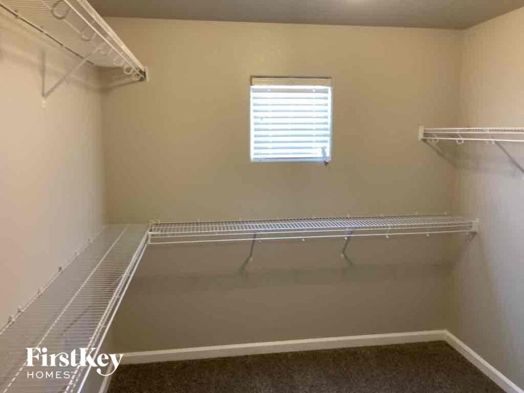 a walk in closet with shelves and a window