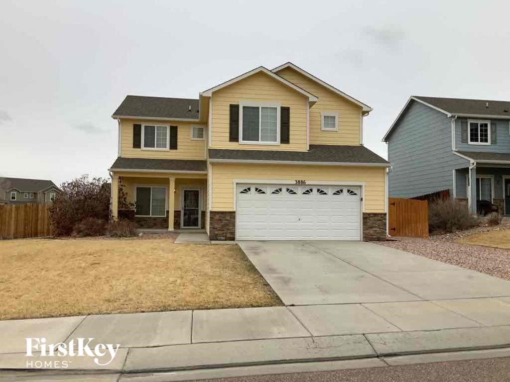 a yellow house with a white garage door