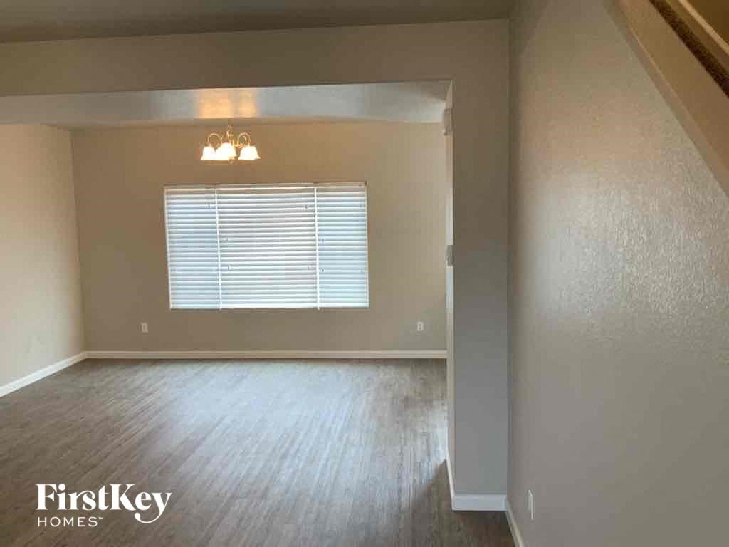 an empty living room with wood floors and a window