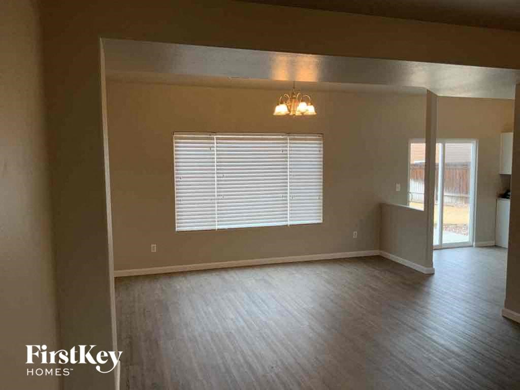 an empty living room with wood floors and a window
