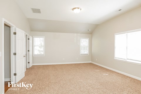 a spacious living room with carpet and a door to a closet