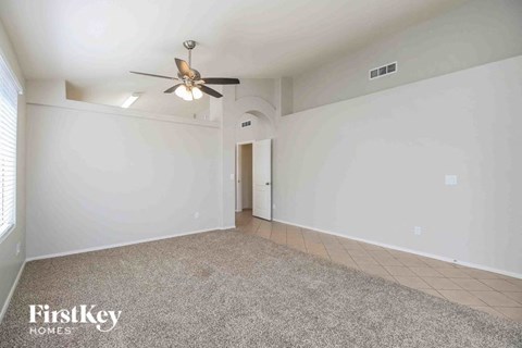 an empty living room with white walls and a ceiling fan