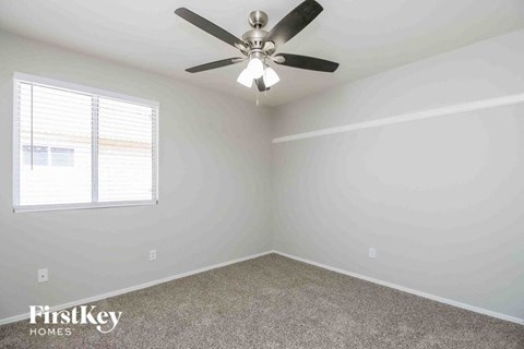 a bedroom with a ceiling fan and a window