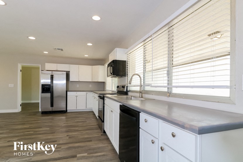 a large kitchen with white cabinets and stainless steel appliances