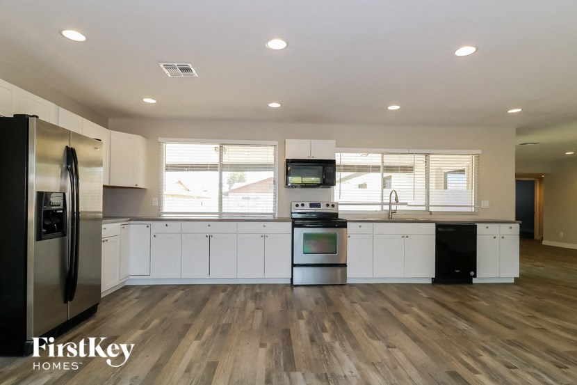 a kitchen with white cabinets and stainless steel appliances