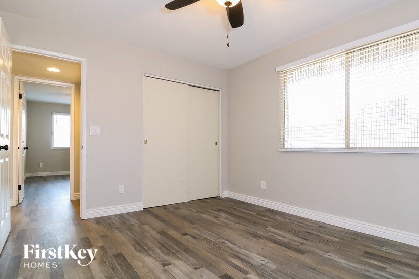 a living room with wood flooring and a ceiling fan